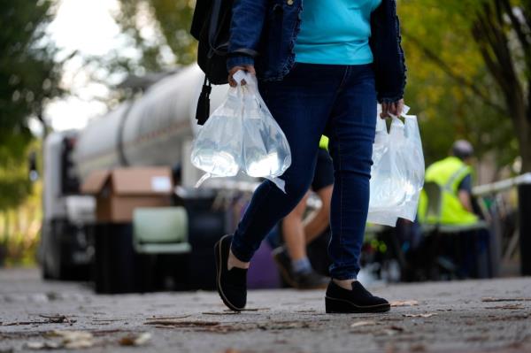 People fill their vehicles's gas tanks and mobile tanks at an Exxon station off Highway 40 on September 29, 2024 in Marion, North Carolina.