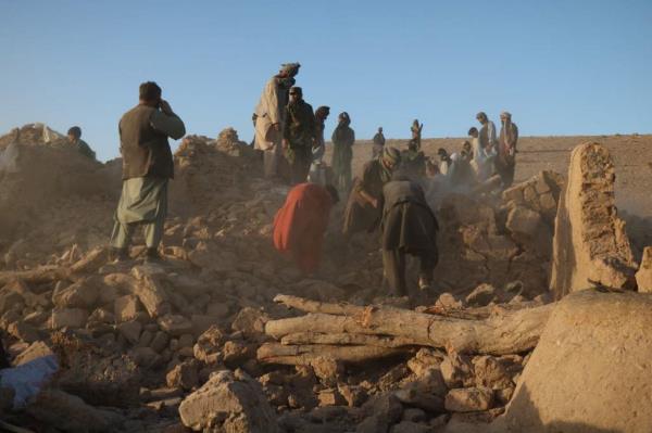 Afghan residents clear debris from a damaged house after Saturday's earthquakes.